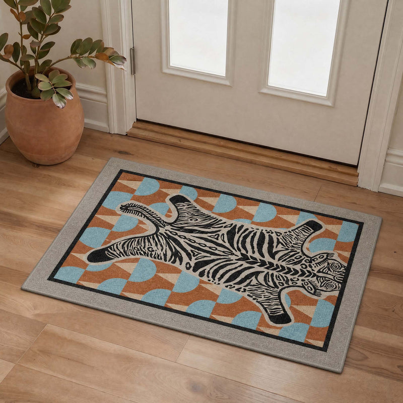 Zuri Washable Zebra Geometric Blue Rug displayed on wood flooring in an entryway with white doors and a potted plant nearby