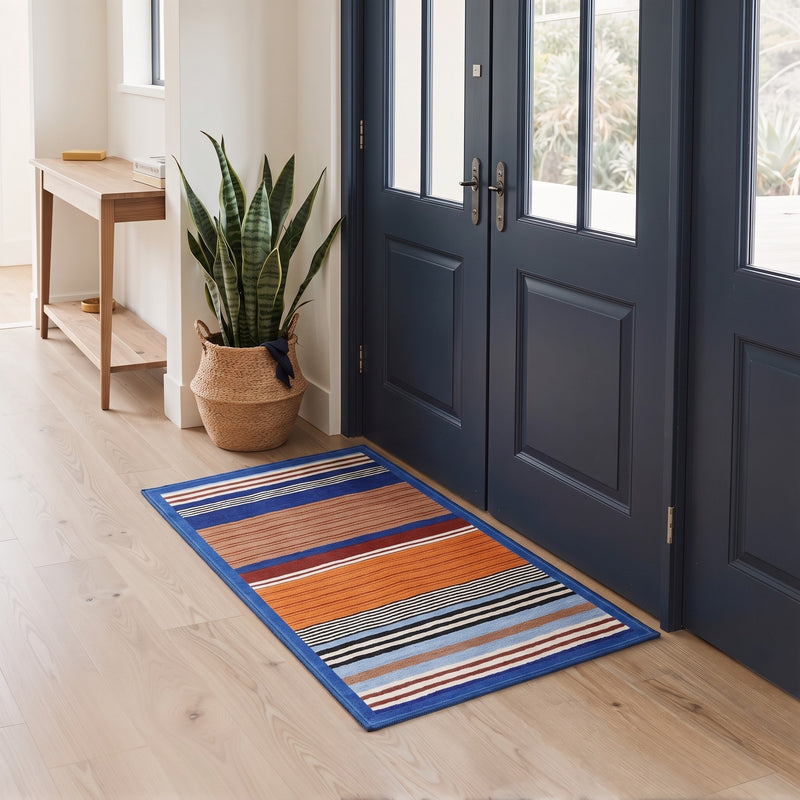 Nerva Washable Modern Striped Orange Rug 3x5 placed at a welcoming front door entryway