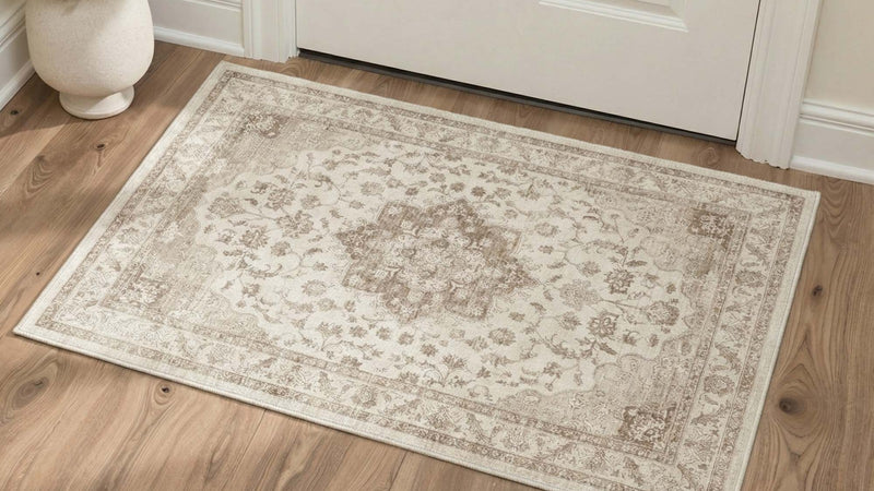 Beige medallion washable rug lying flat on hardwood floor by a door