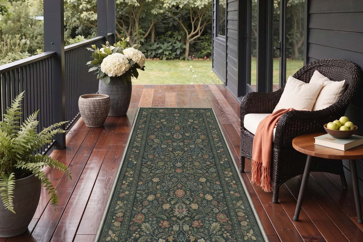 Junia Persian Botanical Green Rug runner on a wood porch beside a wicker chair with a rust throw