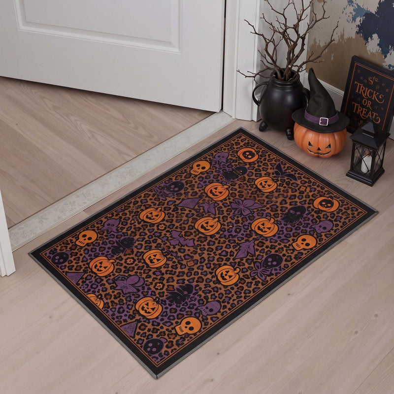 Veris Washable Halloween Abstract Orange Rug on wood flooring in an entryway with jack-o'-lanterns and bats