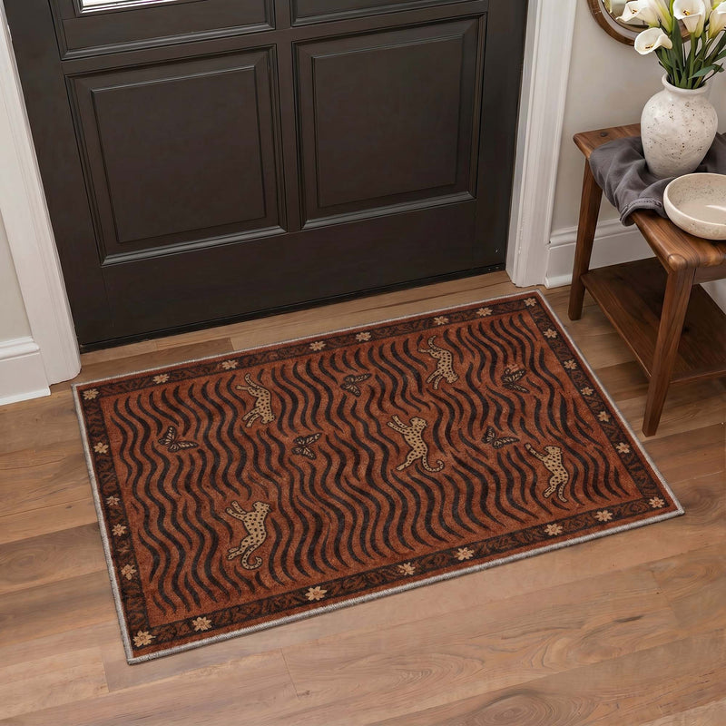 Ember Washable Leopard Print Burgundy Rug placed on wood flooring in an entryway with a black door and wooden chair nearby