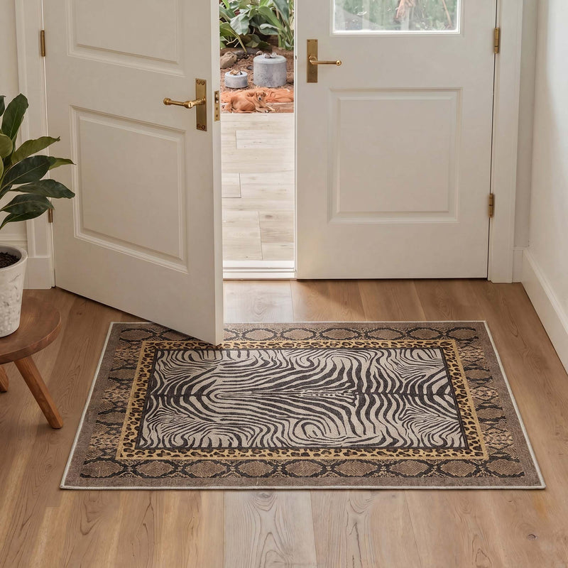 Zorin Washable Zebra Leopard Snake Print Rug placed in an entryway on wood flooring near white doors and a potted plant